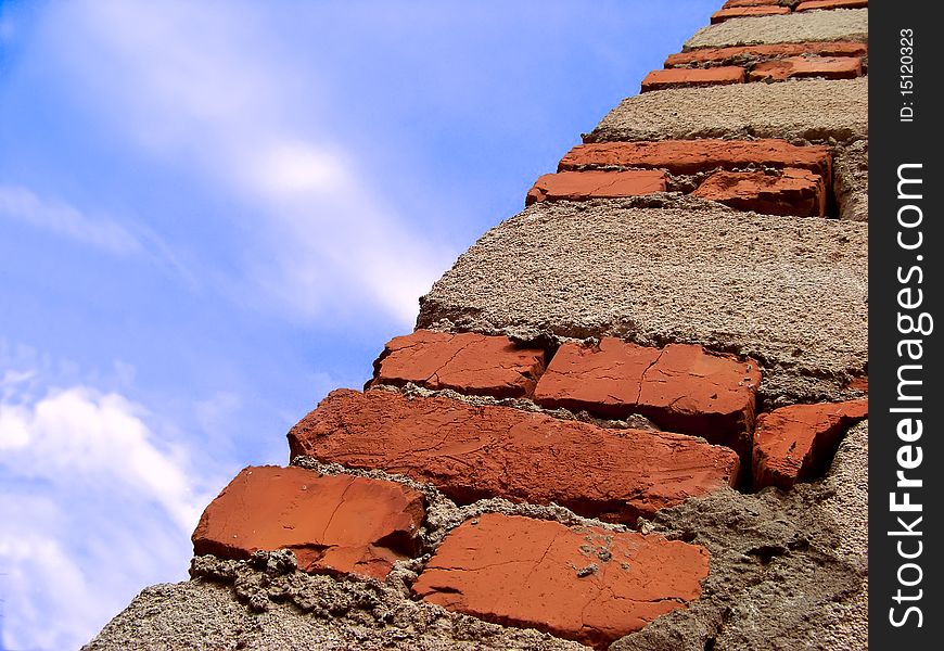 Edge walls of stone and brick on the background of blue sky