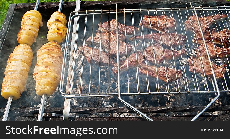 Mutton chops and potato on a grill