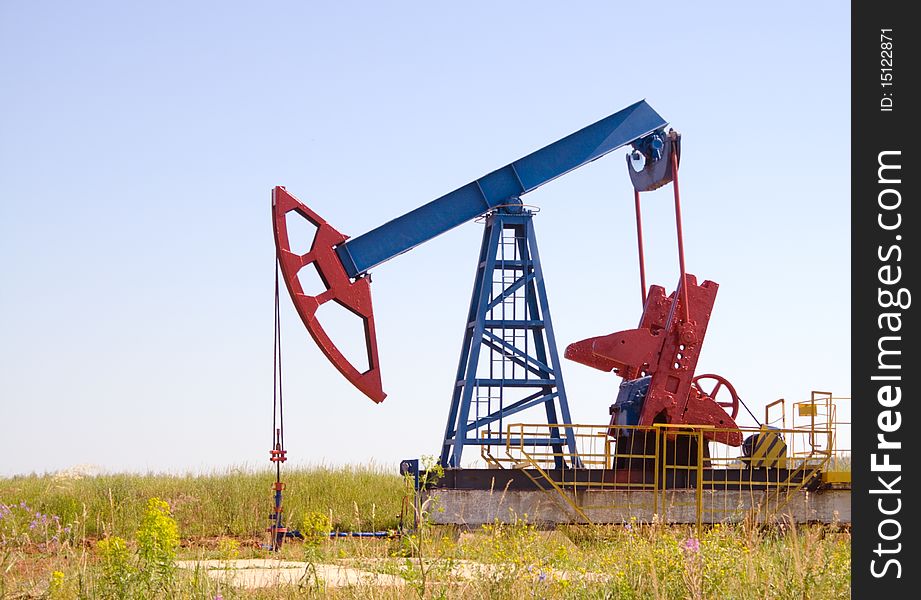 Oil field Pump Jack with a bright blue sky. Oil field Pump Jack with a bright blue sky