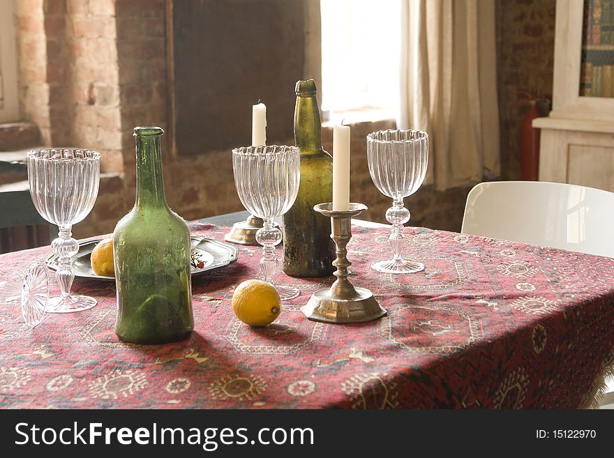 Table with bottles, candles and glasses. Table with bottles, candles and glasses