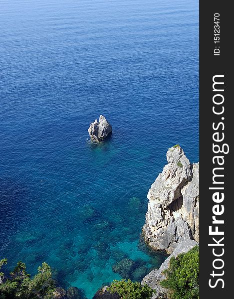 Scenic view of rock in turquoise and blue clear sea, Greek island. Scenic view of rock in turquoise and blue clear sea, Greek island.