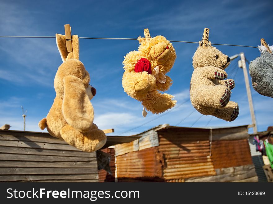 Various teddies hung out to dry in front of shack in a township in South Africa