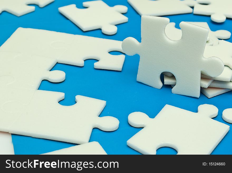 Scattered white jigsaw puzzle pieces