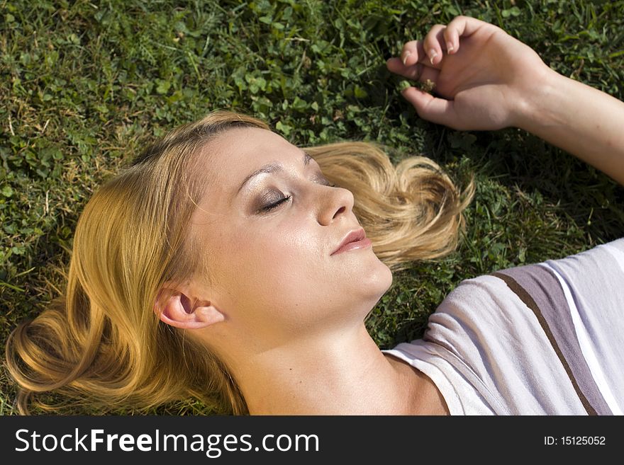 Young woman lying down on her back and enjoying the warm sun. Young woman lying down on her back and enjoying the warm sun.