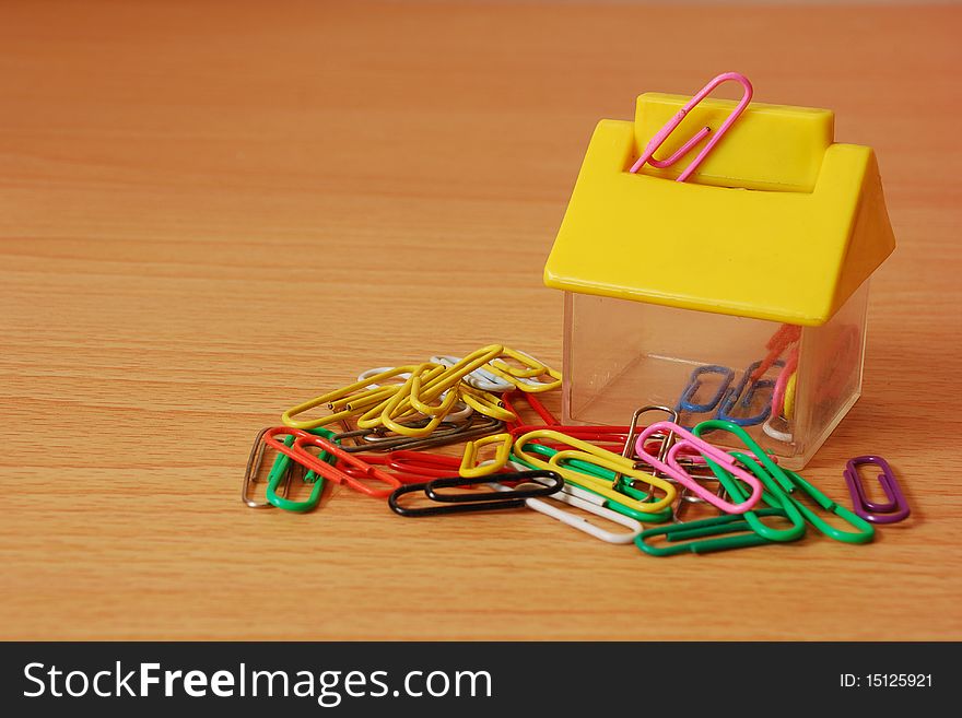 Paper clips with a  house shape container. Paper clips with a  house shape container