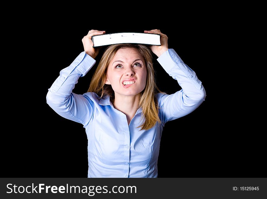 Young female student thrilled and frightened trying to push the book into her head, learning concept, studio shoot isolated on black. Young female student thrilled and frightened trying to push the book into her head, learning concept, studio shoot isolated on black