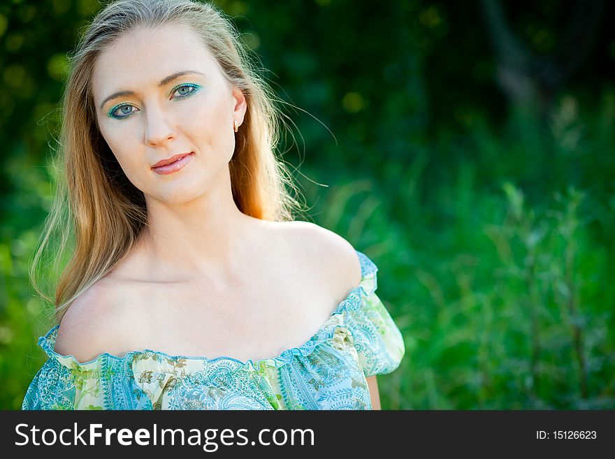 Beautiful woman among green leaves in the forest