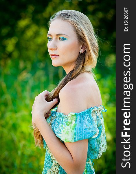 Beautiful woman among green leaves in the forest