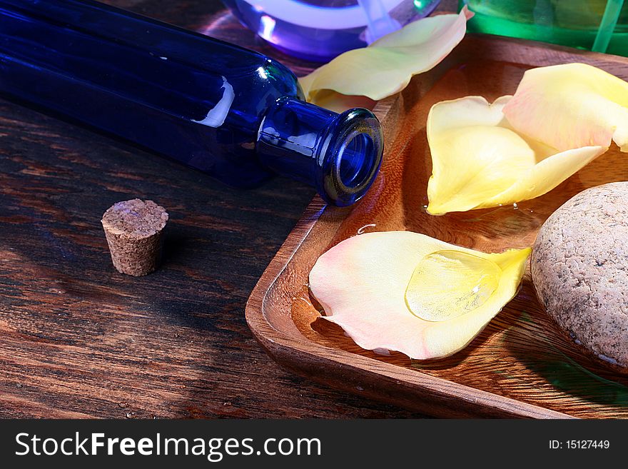 Dark blue bottle with a stopper and flower petals, as accessories SPA of salon.