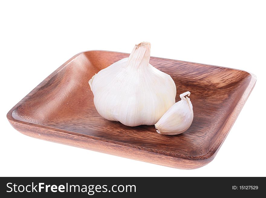 Garlic with small clove on a wooden square plate. Garlic with small clove on a wooden square plate.