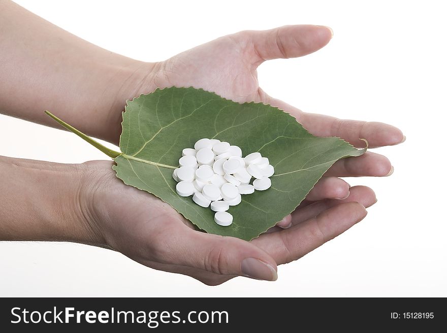 Tablet on the green leaf isolated on white