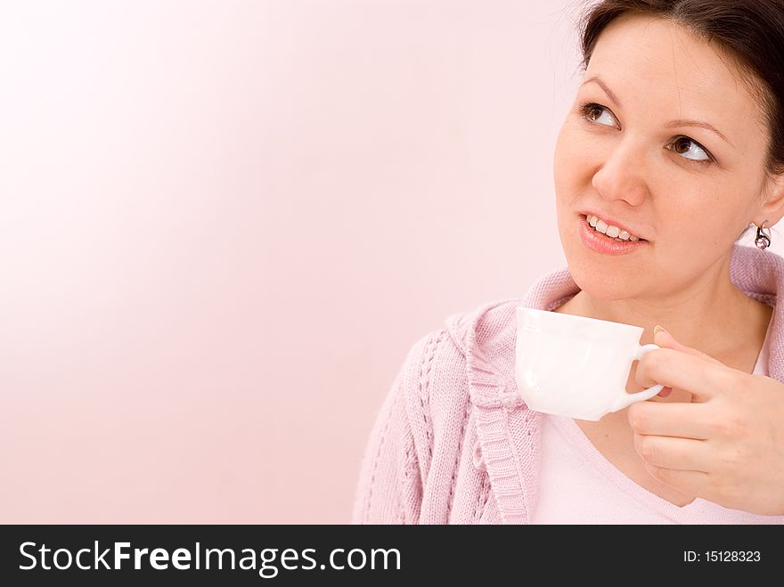 Beautiful woman drinking coffee on a pink