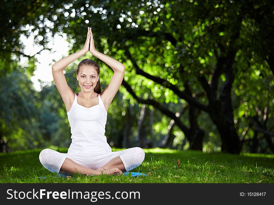 An attractive girl in a pose of yoga outdoors. An attractive girl in a pose of yoga outdoors