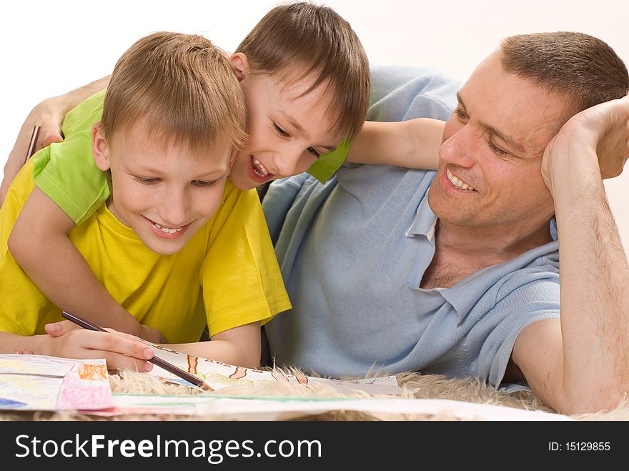 Father and two young brothers lying on the carpet