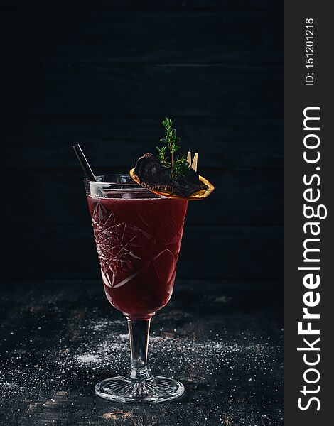 Alcoholic cocktail. Rum, peach liquor, cherry juice. On a black wooden background