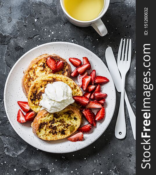 Baked french toast with ice cream and strawberries on a dark background, top view. Delicious breakfast, dessert, snack.Flat lay.