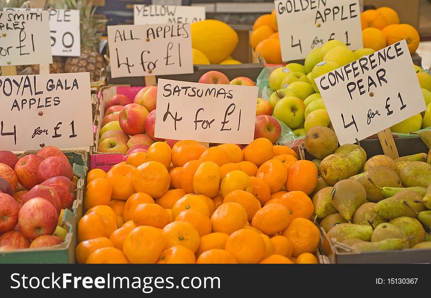 An image of fresh, organic fruits for sale on a market stall in England showing price labels. An image of fresh, organic fruits for sale on a market stall in England showing price labels.