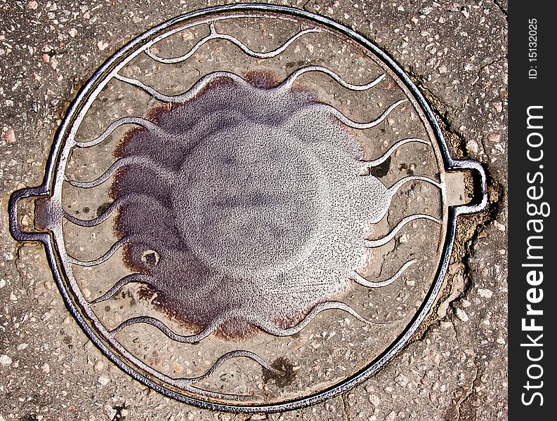 Old manhole cover in asphalt