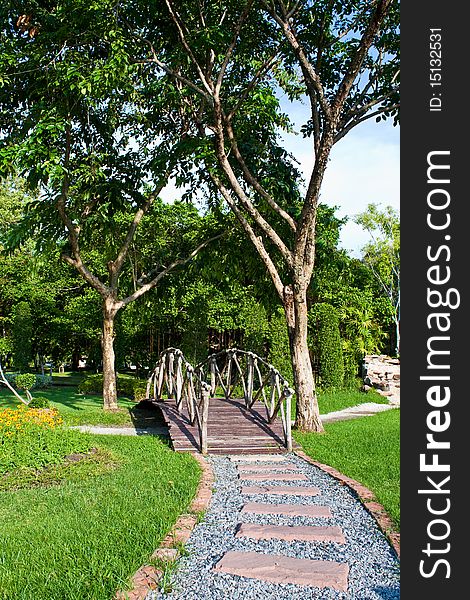 Stone walk way to wooden bridge in garden. Stone walk way to wooden bridge in garden