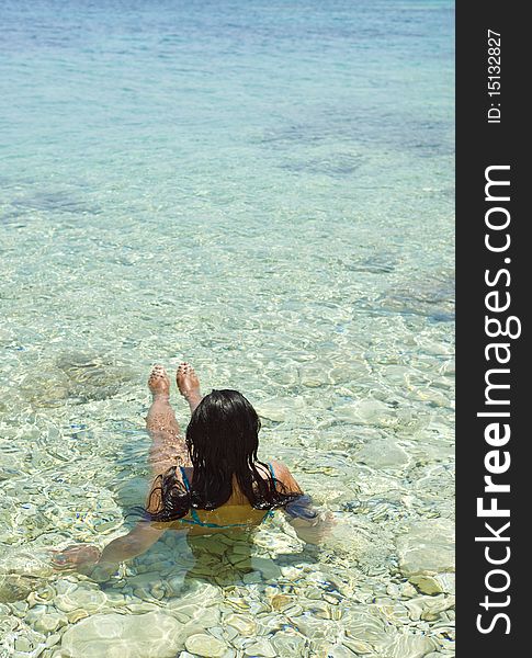 A color portrait photo of a beautiful woman relaxing in the clear blue sea of the ionian region in Greece. A color portrait photo of a beautiful woman relaxing in the clear blue sea of the ionian region in Greece