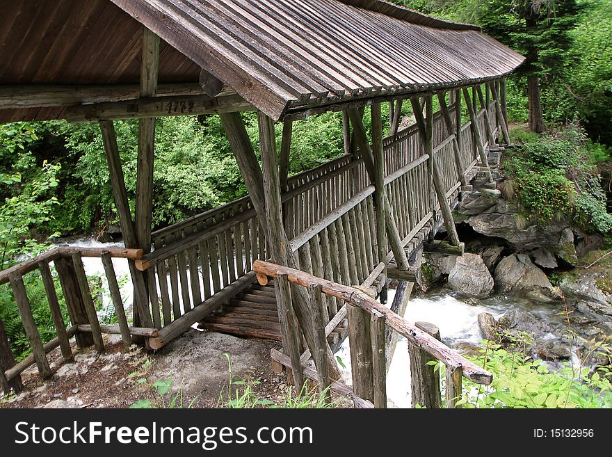 A wooden bridge along the riverside of Santantonio river, in Santantonio's Valley, Lombardy, Italy.