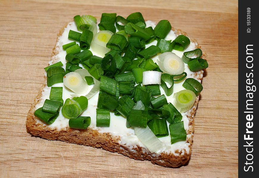 A slice of bread with green onion. A slice of bread with green onion.