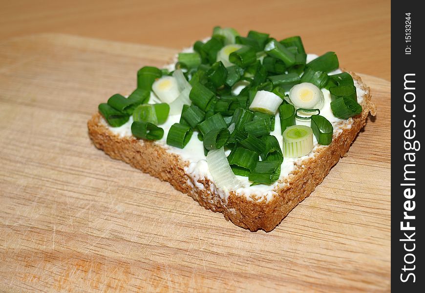 A slice of bread with green onion. A slice of bread with green onion.