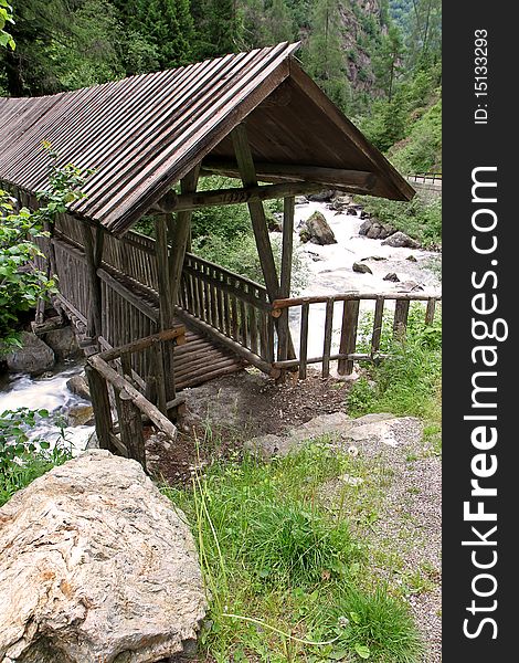 A wooden bridge along the riverside of Santantonio river, in Santantonio's Valley, Lombardy, Italy.