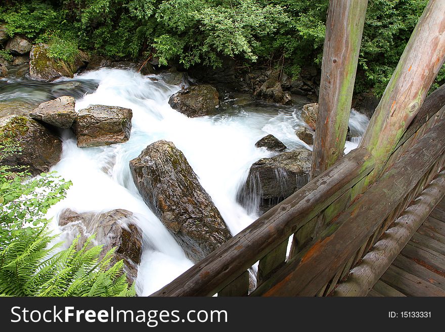 A wooden bridge along the riverside of Santantonio river, in Santantonio's Valley, Lombardy, Italy.