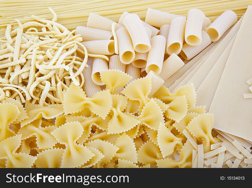 Different kinds of uncooked macaroni background. Different kinds of uncooked macaroni background