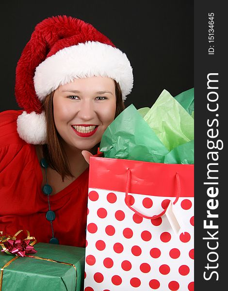 Beautiful brunette female with christmas gifts wearing a fluffy hat. Beautiful brunette female with christmas gifts wearing a fluffy hat