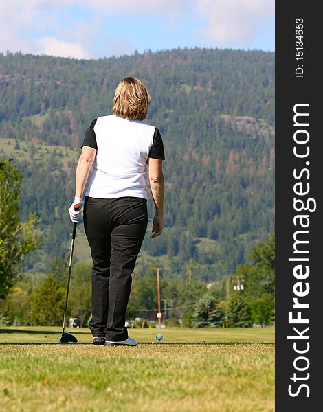 Mature blond female waiting to take a tee-shot. Mature blond female waiting to take a tee-shot