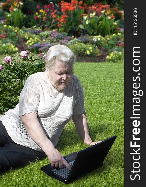 Senior woman with laptop in the garden. Senior woman with laptop in the garden.