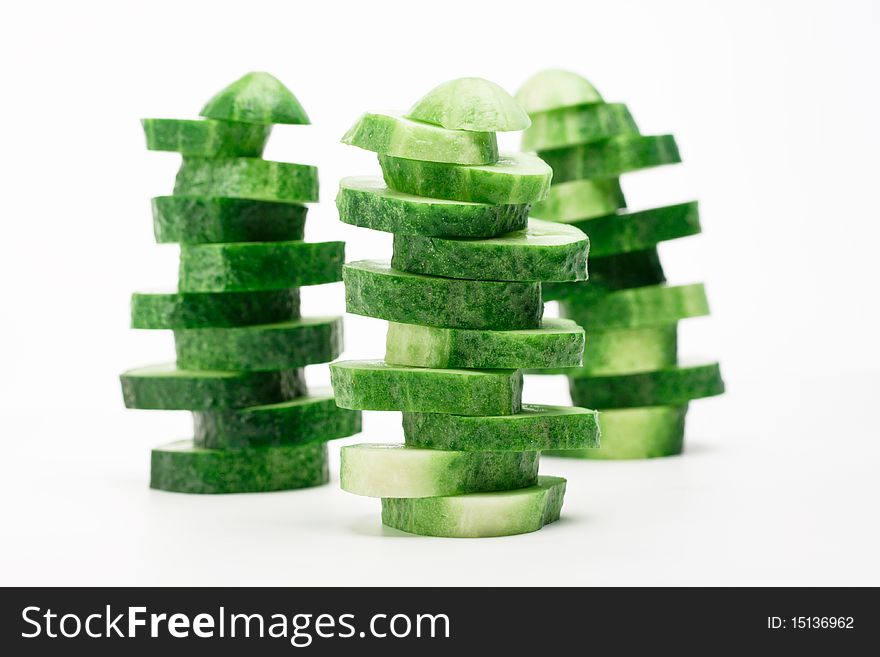 Of sliced cucumbers built tower on a white background. Of sliced cucumbers built tower on a white background