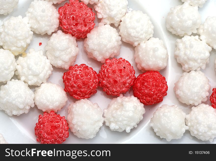 Small red and white Sweet on a small dish. Small red and white Sweet on a small dish