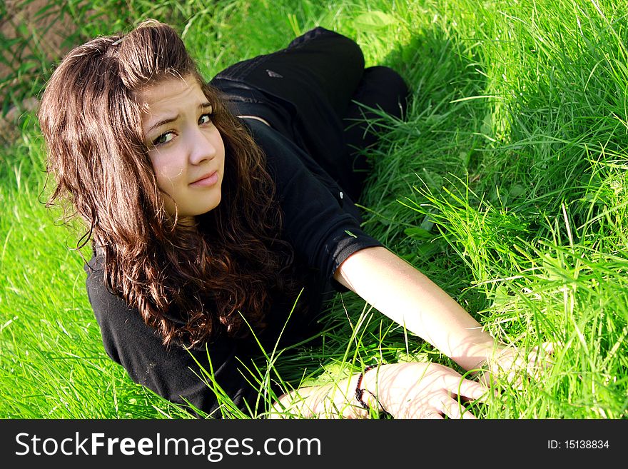 Girl the teenager lies on a green grass. Girl the teenager lies on a green grass.