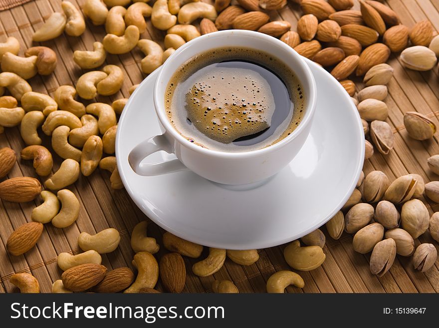 Delicious coffee with nuts on the background. Delicious coffee with nuts on the background