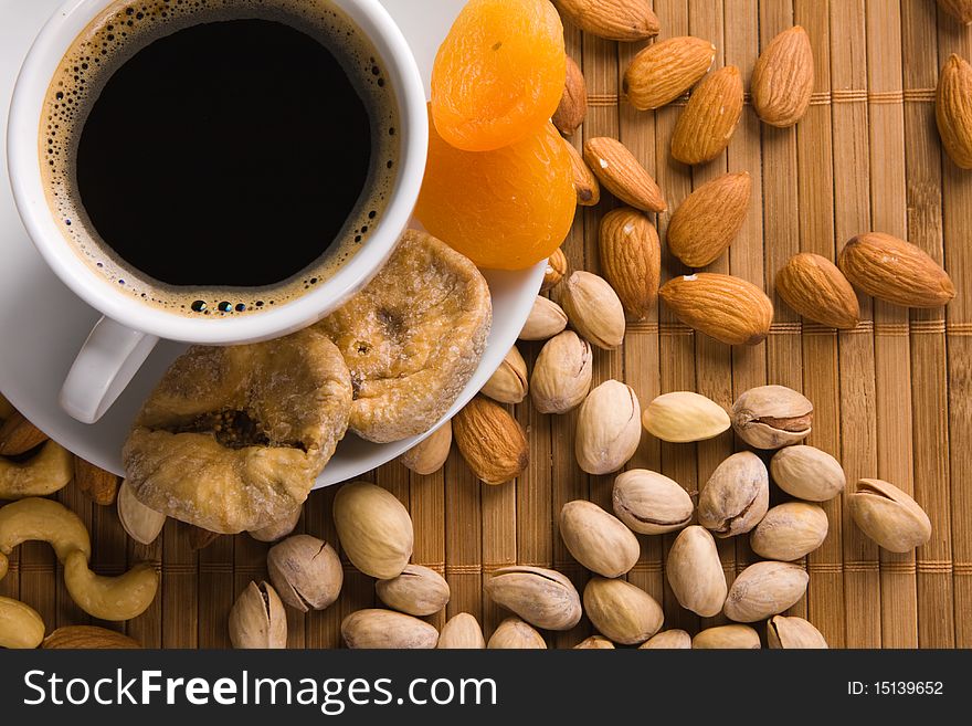 Coffee with nuts, fig and dried apricots still life