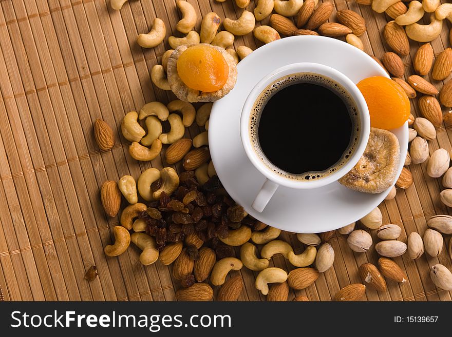 Coffee with nuts, fig and dried apricots still life
