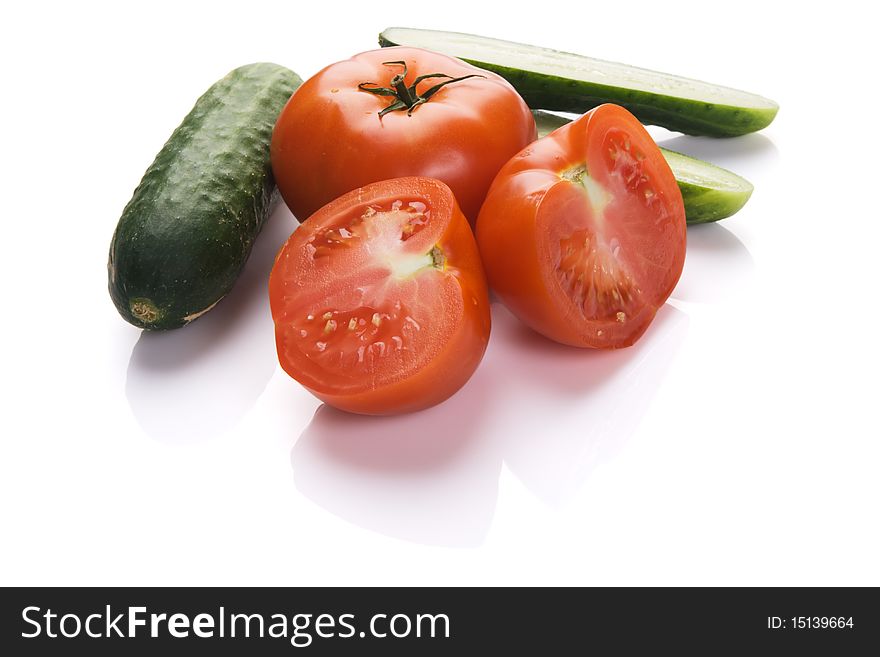 Tomatoes and cucumbers on white background