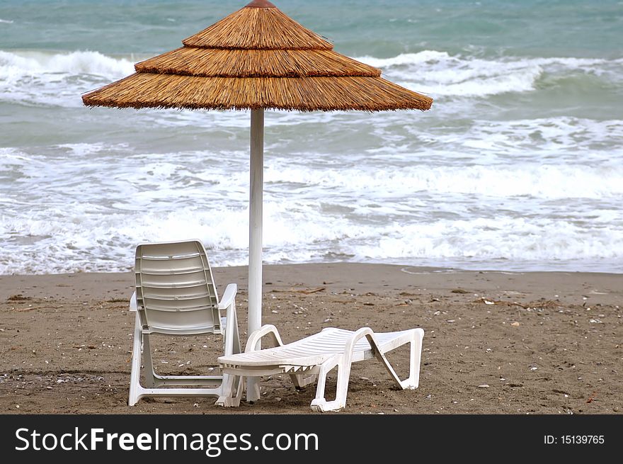 Parasol and deck chairs on the beach in winter. Parasol and deck chairs on the beach in winter