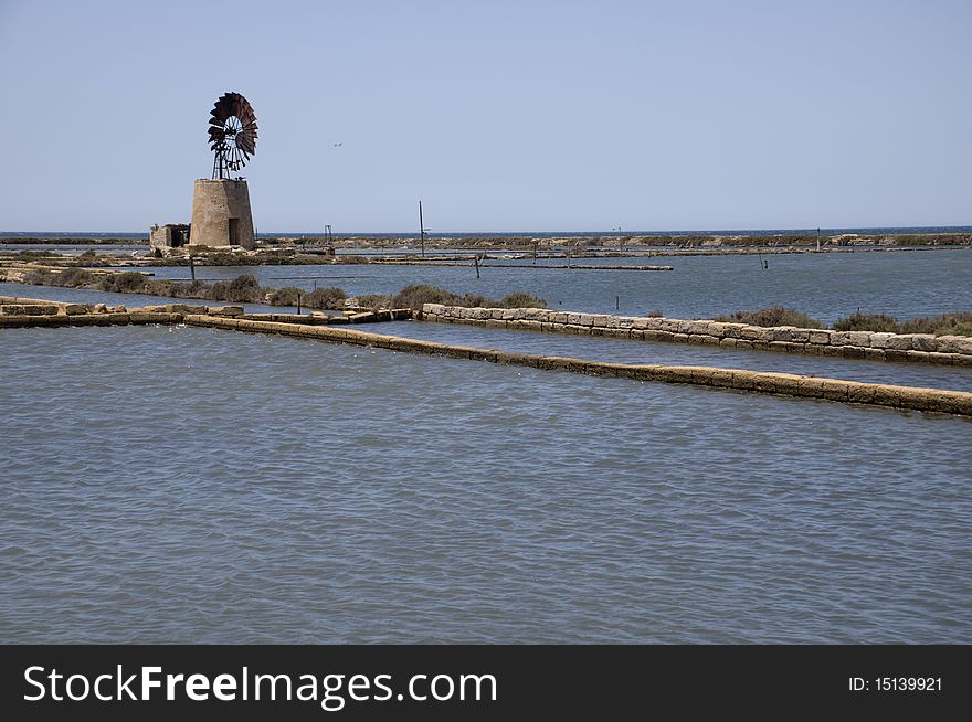 Old windmill and salt marshes at Infersa Salt Pans, Marsala, Sicily, Italy
