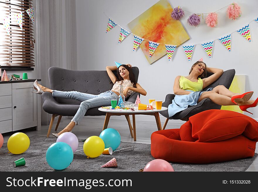 Young women sleeping in messy room after party