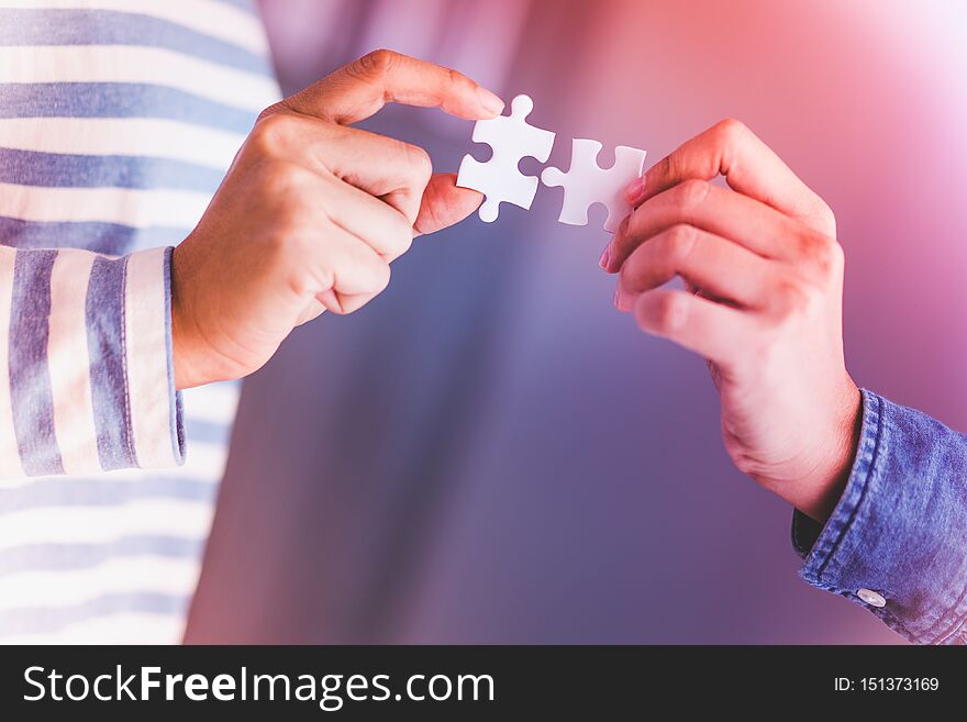 Jigsaw puzzle holding by two people hands, together to success concept