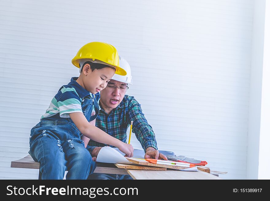 Builder Father teaching his son to read the construction plan paper