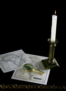 A Candle With Old Maps And Magnifying Glass Stock Photo A Candle With Old Maps And Magnifying Glass Stock Photo