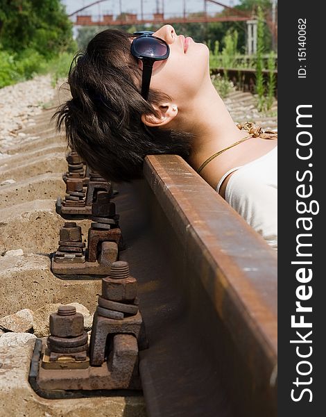 Young attractive brunette lying on the railway carelessly. Young attractive brunette lying on the railway carelessly