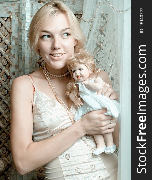 The beautiful blonde with a doll. The beautiful blonde with a doll