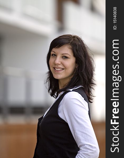 Smiling and good looking business woman in front of a modern business building. Smiling and good looking business woman in front of a modern business building