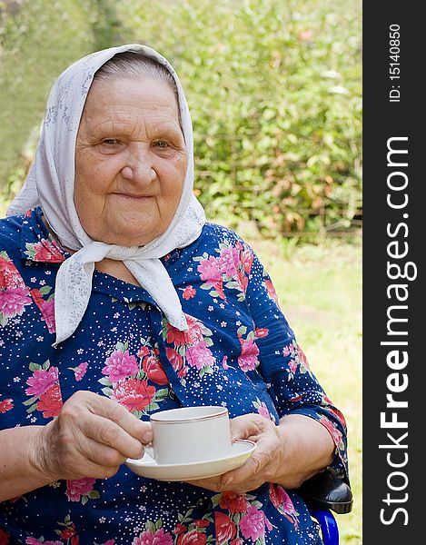 Portrait of the old woman drinking tea